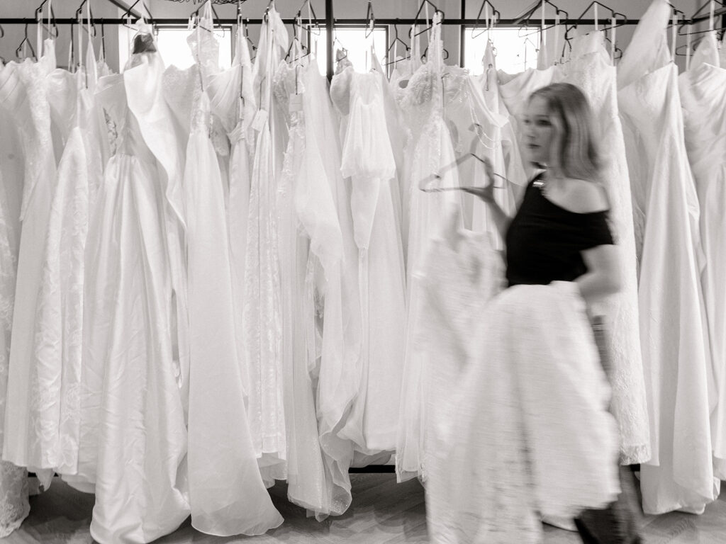 Bride in a bridal boutique fitting room choosing her wedding dress with her consultant